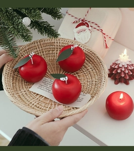 Artistic close-up of handmade apple-shaped candle and Christmas tree candle decoration