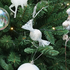 Addobbo natalizio a forma di caramella trasparente con glitter bianchi su albero verde