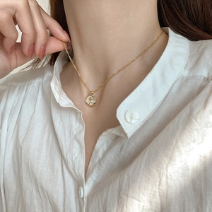 Detail of French tulip pendant necklace with white mother of pearl on a gold chain