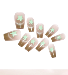 Detail of coffin-shaped gradient cat eye press-on nails with green star accents