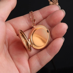Close-up of rose gold stainless steel round locket necklace with mirror finish