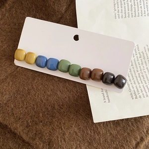 Detailed close-up of colorful resin square beads on a stylish hair clip with display card