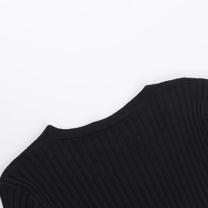 Close-up of black ribbed knit fabric showing the deep V-neckline texture and stitching