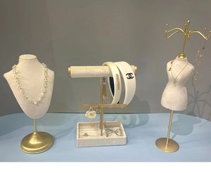 Jewelry display props including beaded necklace and earrings on gold metal stands