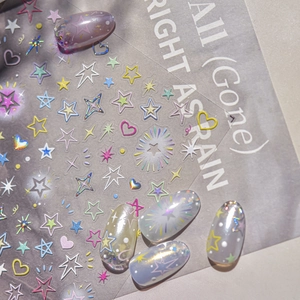 Macro view of holographic star and heart embossed nail art stickers on purple nails