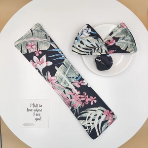 Close-up of fabric hair bun maker and bow scrunchie with pink tropical floral pattern