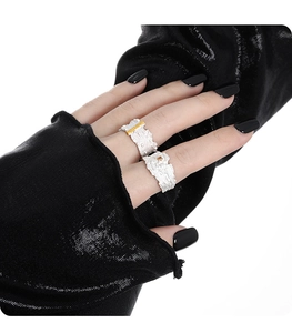 Detail of silver textured rings with gold bar and amber stone worn by model