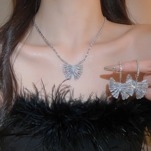 Gros plan d'un ensemble collier et boucles d'oreilles papillon en zircon sur mannequin