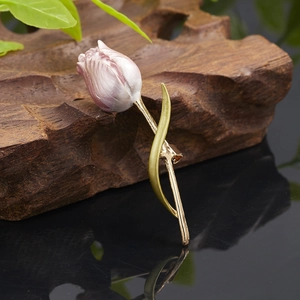 Macro detail of tulip brooch featuring pearlescent petals and champagne gold leaf finish