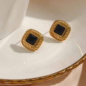 Macro shot of 18K gold plated earring with black square zircon and spiral texture detail