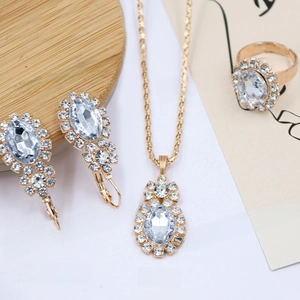 Detailed view of bridal jewelry set featuring oval crystal pendant, earrings and ring