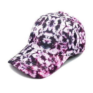 Detail of purple and black tie-dye baseball cap with curved brim and twill cotton fabric