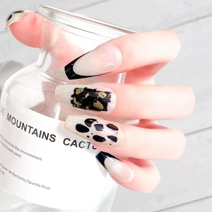 Long French press-on nails featuring black and gold foil with leopard print pattern