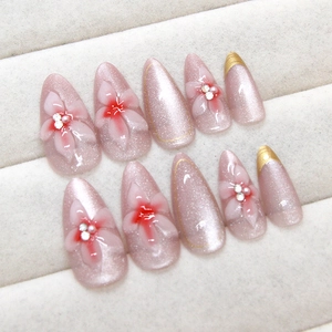 Pink cat eye press-on nails with 3D floral carvings and sparkling rhinestones