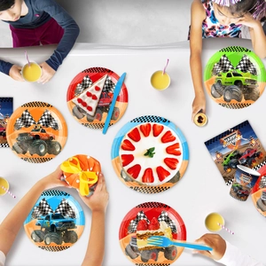 Flat lay of monster truck party set featuring paper plates, cups and Happy Birthday napkins