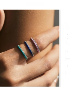 Close-up of stacked colorful enamel rings with sparkling zircon pavé on model's hand