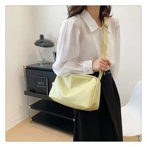 Detailed view of the soft cream yellow crossbody tote bag styled in a modern interior setting