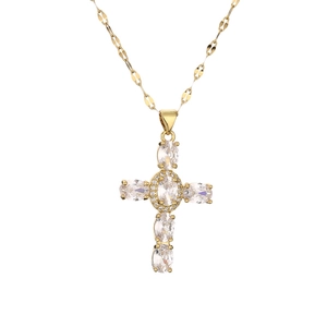 Detailed view of a gold cross pendant with oval-cut zircons and flat chain necklace
