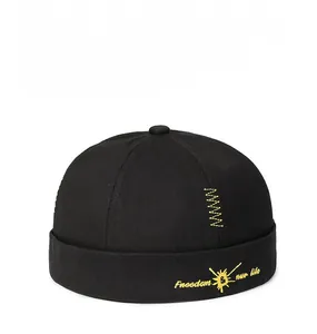 Detail of yellow embroidery on black cotton docker hat with freedom lettering