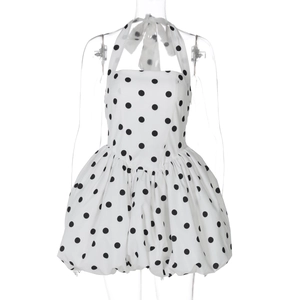 Detail of white polka dot halter dress featuring a gathered waist and bubble hemline