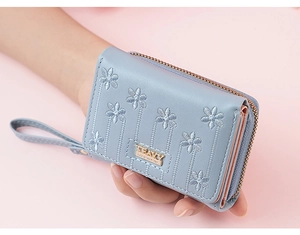 Detail of light blue short PU leather wallet with floral embroidery and wrist strap