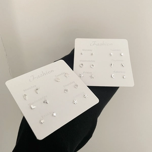Dettaglio del set di orecchini a lobo in argento con luna, stella e forme geometriche