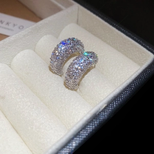 Macro shot of silver C-shaped hoop earrings with micro-pave cubic zirconia inlay