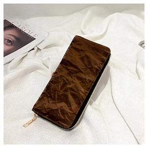 Detail of dark brown long velvet wallet with wrinkled texture and gold zipper puller
