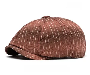 Close-up of red striped baker boy hat with retro British texture and top button detail