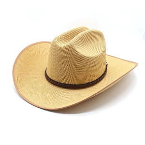Detail of hand-woven straw cowboy hat featuring a dark brown braided leather band