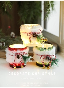 Detail of Christmas glass jars with white faux fur, pine cones and warm glowing lights