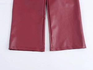 Gros plan détaillé montrant les coutures lisses et la texture du pantalon en cuir PU rouge