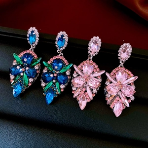 Detail of tear-drop earrings featuring colorful crystals and intricate floral petal designs