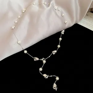 Collana di perle irregolari con pendente rosa argentata su sfondo di seta fine