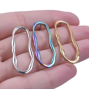 Detailed view of wave-shaped oval earrings in silver, rainbow, and matte gold finishes