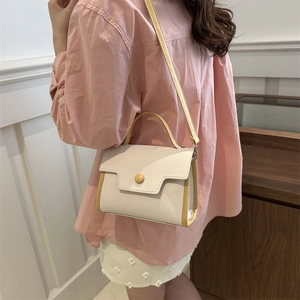 Minimalist cream shoulder bag with yellow trim shown on a model for size and style