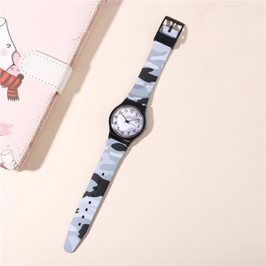 Detail of quartz watch with blue camouflage pattern strap and dial on white background