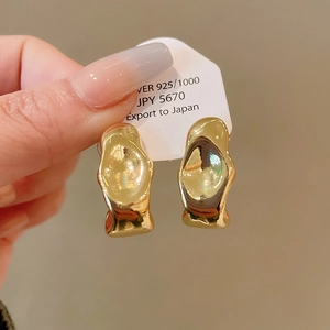 Close-up of gold geometric 925 silver stud earrings with artistic lava texture design