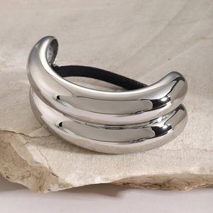 Macro view of polished silver stainless steel hair tie cuff on natural stone