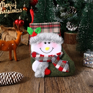 Detail of Christmas stocking featuring 3D snowman design and festive plaid top trim