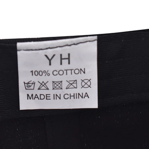 Détail de l'étiquette d'entretien 100% coton pour casquette noire avec symboles de lavage
