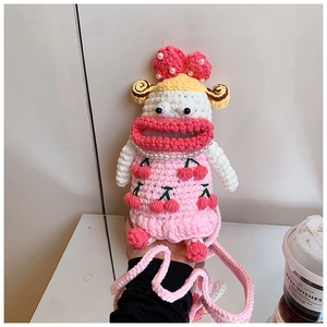 Handmade pink crochet crossbody bag with cute cartoon doll face and cherry detail