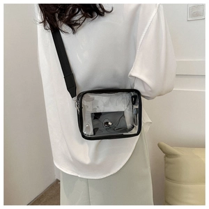 Detailed view of transparent jelly crossbody bag with black trim worn by model