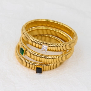 Three gold-plated Tubogas bracelets with emerald, white, and black zircon gemstone centers