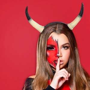 Realistisches Teufelshorn Stirnband für Halloween Partys an einem Model vor rotem Hintergrund