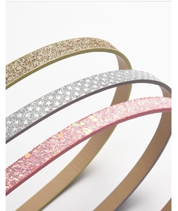 Close-up of sparkling gold silver and pink sequin headbands with shimmering star patterns