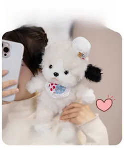 Close-up of cute white plush puppy toy with pink cherry blossom bib and floppy black ears