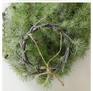 Detailed close-up of realistic green pine needles and natural vine base for Christmas decor