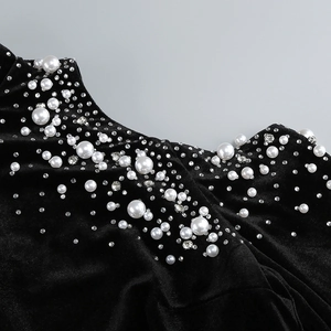Detailed view of elegant black velvet fabric with exquisite pearls and sparkling rhinestones