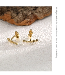 Macro shot of gold-plated luster and elegant white pearls on these minimalist earrings